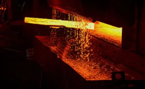 heißes Eisen in der Schmelze von einem Arbeiter gehalten. Eisenschmelzrecycling wo